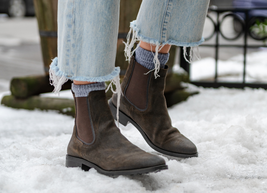 A women standing in snow while wearing the Thursday Duchess Chelsea boots