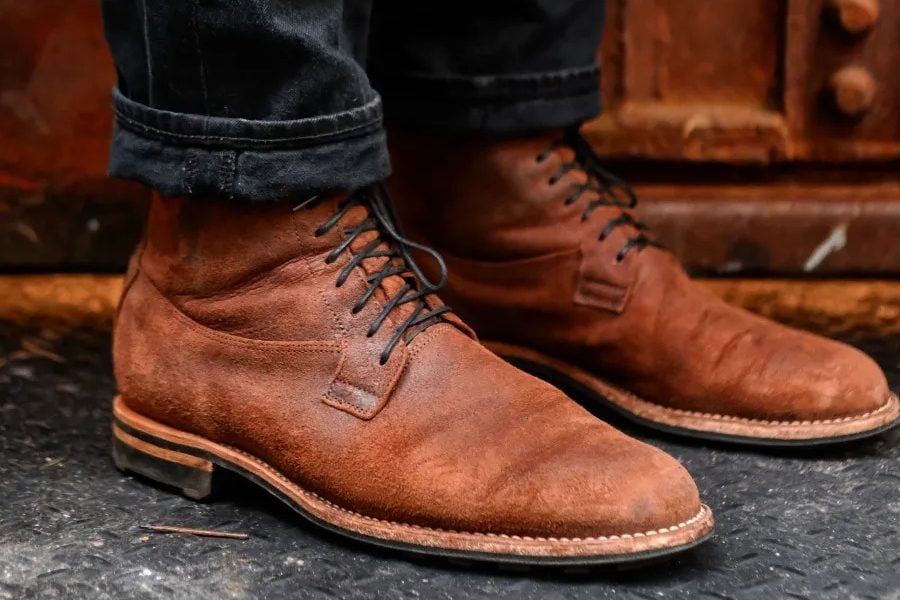 Viberg and Miloh collab boot on foot with wood cabinet background